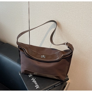 Detail view of vintage dark brown tote bag with silver twist lock on black book