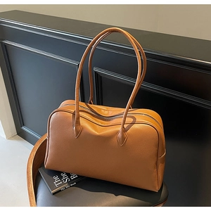 Dettaglio della borsa tote in pelle martellata caramello con lunghi manici neri