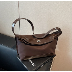 Detail view of brown nylon and leather shoulder bag with silver metallic twist lock closure