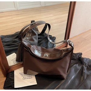 Detail view of vintage dark brown hobo bag with contrast textures and silver turn lock
