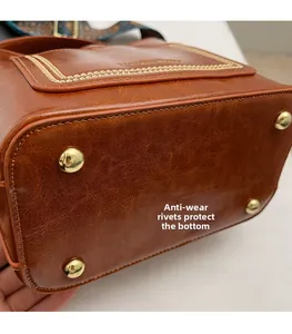Primer plano del fondo del bolso cubo marrón con remaches dorados de protección