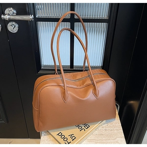 Vista dettagliata della borsa tote marrone grana litchi con manici lunghi e zip in metallo