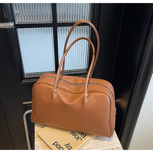 Dettaglio della pelle martellata marrone caramello e della cerniera di una grande borsa