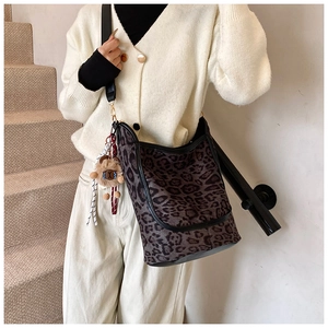 Detail of leopard print bucket bag with adjustable strap and cute plush bear charm