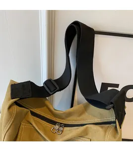 Detailed close-up of smooth adjustable strap and sturdy double zippers on canvas tote bag