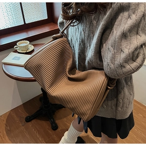 Detail view of caramel brown pleated shoulder bag with soft accordion folds and leather texture
