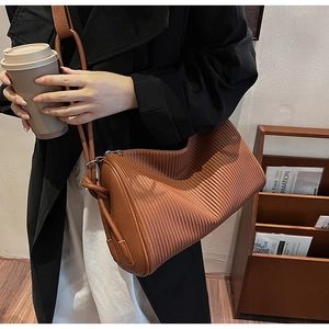 Detailed view of caramel pleated faux leather texture on this stylish shoulder bag