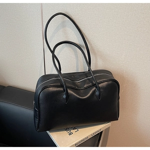 Dettaglio della pelle nera con motivo lychee e della cerniera argentata su questa borsa