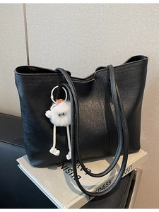 Large black leather tote bag with lychee texture and a cute white plush monster charm