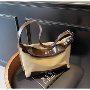 Detail of vintage canvas tote with brown leather trim and silver metal turn-lock closure