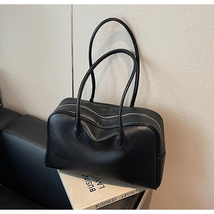 Dettaglio della borsa Boston in pelle martellata nera con tracolla sottile e cerniera