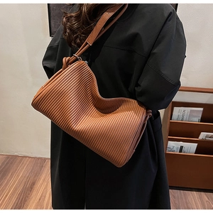 Close-up of caramel brown pleated leather texture on a stylish shoulder pillow bag