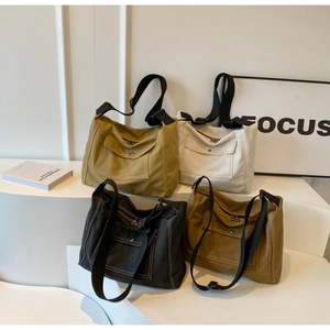Detail of four colorful canvas messenger bags with flap pockets and wide shoulder straps