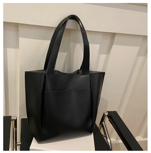 Close-up of black PU leather tote bag with lychee texture and front slip pocket detail