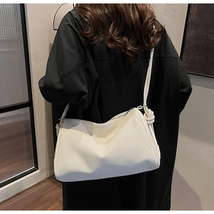 Detail of white pleated Boston shoulder bag featuring stylish knotted strap accents