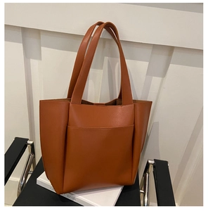 Brown leather tote bag featuring a front pocket and long shoulder straps for daily commute
