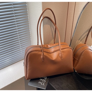 Macro della texture in pelle marrone e dettagli della zip su una borsa tote minimalista