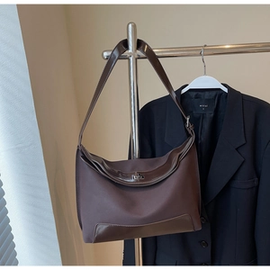 Close-up of vintage tote bag featuring canvas and leather textures with metal buckle