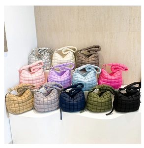 Close-up of quilted puff shoulder bag showing adjustable strap and silky nylon texture