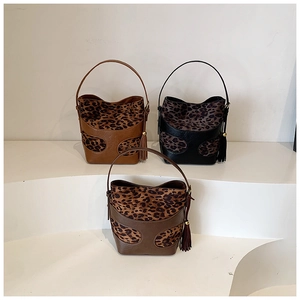 Three retro bucket bags in brown, black, and coffee colors with leopard print and tassels