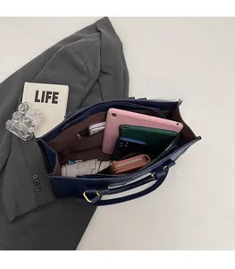 Spacious interior of a deep blue tote bag showing compartments for tablet and umbrella