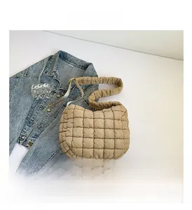 Close-up of the beige quilted bubble bag showing its unique square puffy texture and soft fabric