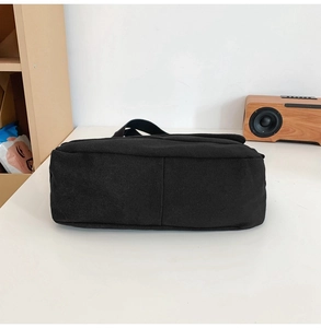 Detailansicht der Unterseite einer großen schwarzen Canvas-Tasche mit Stofftextur und Nähten