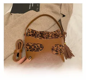 Detail of vintage brown leather bucket bag with leopard print and decorative tassel