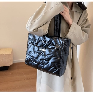 Gros plan du sac cabas matelassé noir brillant avec étiquette de mode contemporaine