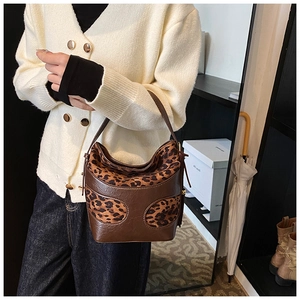 Detail of vintage leopard print patchwork bucket bag in brown leather on model