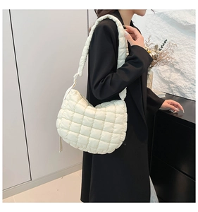 Detail of white quilted cloud bag with padded strap and puffy puffer texture