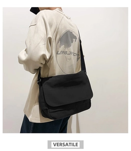 Seitenansicht einer schwarzen Canvas-Umhängetasche, getragen im minimalistischen Stil