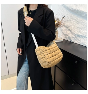 Detail view of khaki quilted nylon puff bag featuring soft texture and adjustable strap