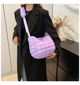Close-up of a stylish quilted purple puff handbag worn with a black blazer for daily style