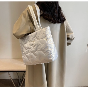 Détail du sac fourre-tout matelassé blanc avec texture soyeuse et étiquette Fashion