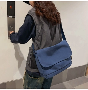 Blaue Canvas-Kurier-Tasche am Model mit großem Stauraum für den täglichen Weg