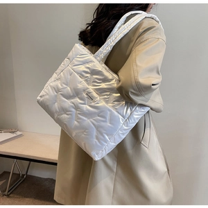 Détail du sac cabas matelassé blanc avec finition brillante et grande couture en V