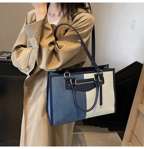 Detail of color-block denim tote bag with leather straps and front zip pocket