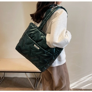 Détail du sac cabas matelassé vert foncé avec poche latérale et étiquette tissée mode