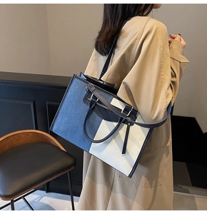 Detail of color-block denim tote bag showing fabric texture and decorative zipper