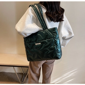 Détail du grand sac cabas matelassé vert foncé avec texture brillante et étiquette mode