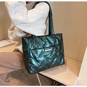 Détail du sac cabas matelassé vert foncé avec aspect métallisé et logo de mode