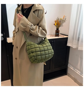 Detail of olive green quilted cloud bag with puffy grid texture and adjustable strap