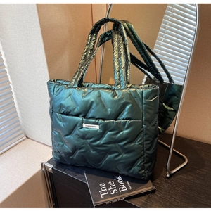 Détail macro du sac cabas matelassé en nylon vert foncé avec étiquette de mode épurée