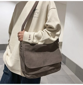 Detailansicht der Seitentasche und des breiten Gurtes dieser braunen Segeltuchtasche