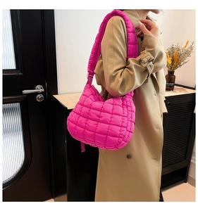 Quilted puffy shoulder bag in hot pink styled with a trench coat for an autumn casual look