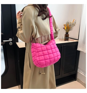 Detailed view of pink quilted puffer shoulder bag showing fluffy texture and strap