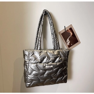 Détail du sac cabas matelassé argenté avec texture métallique et design rembourré