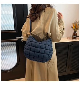 Quilted blue hobo bag shown on a model, highlighting its puffy texture and large capacity