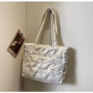Détail du sac cabas matelassé blanc perle avec coutures en losanges et étiquette mode